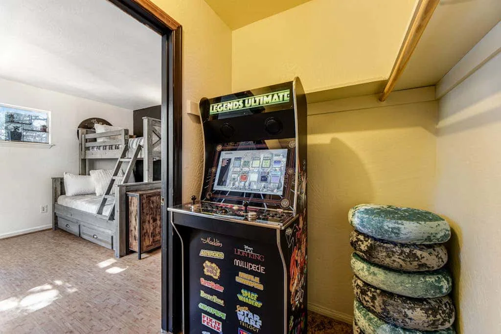 Una sala de juegos tiene una máquina recreativa junto a una pila de cojines redondos.