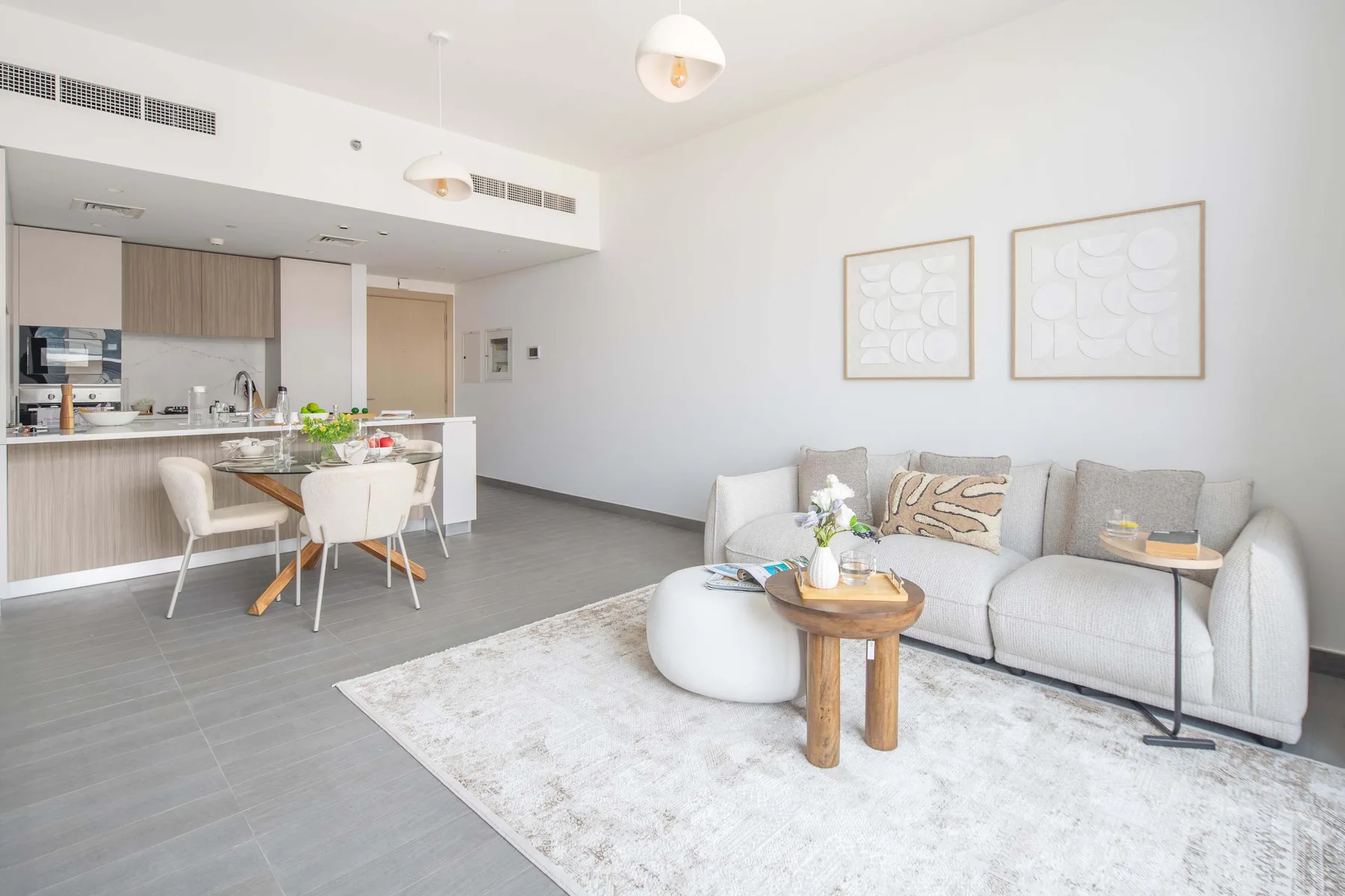 Una luminosa sala de estar y cocina diáfanas con sofá y mesa de comedor.