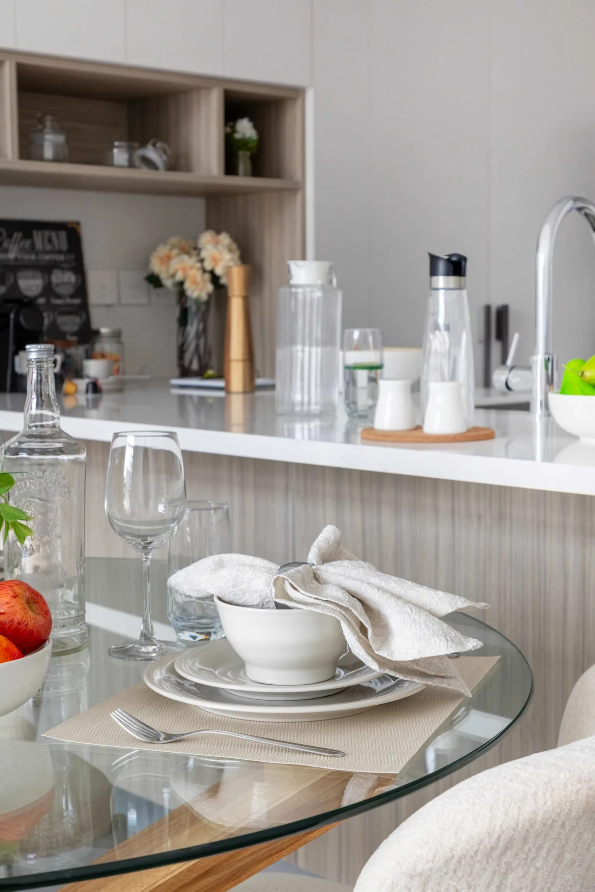 Una mesa de comedor con platos está frente a una encimera de cocina.
