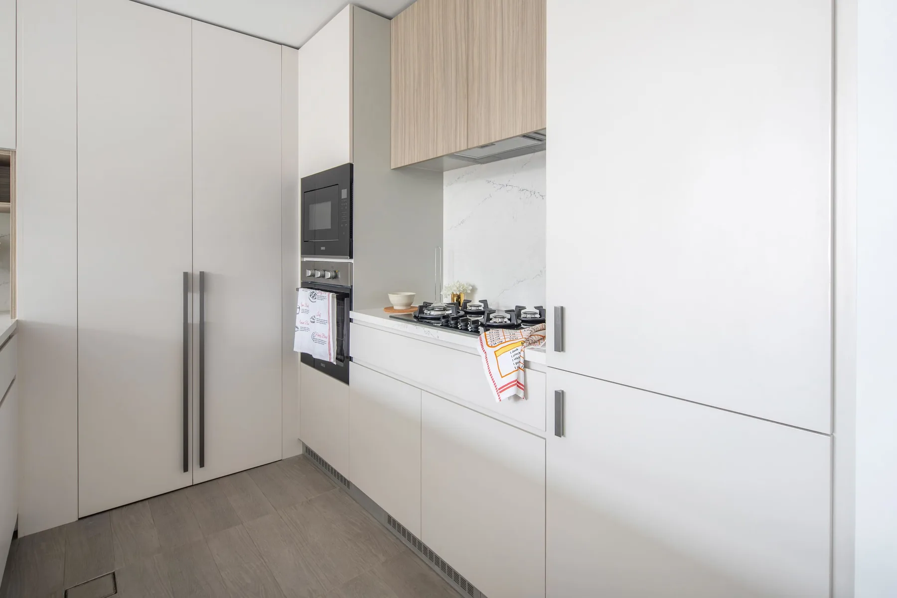 Una cocina moderna con electrodomésticos integrados y una placa de cocción sobre la encimera.