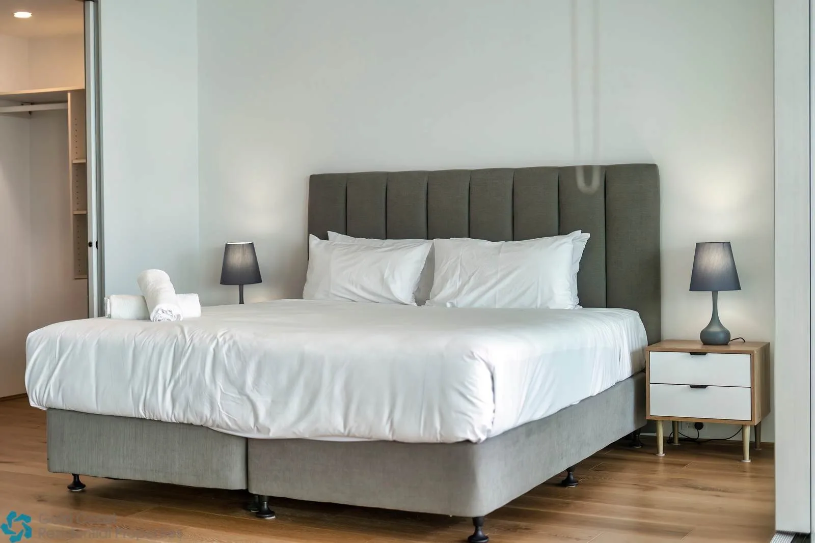 Un dormitorio con una cama grande, mesitas de noche y lámparas.