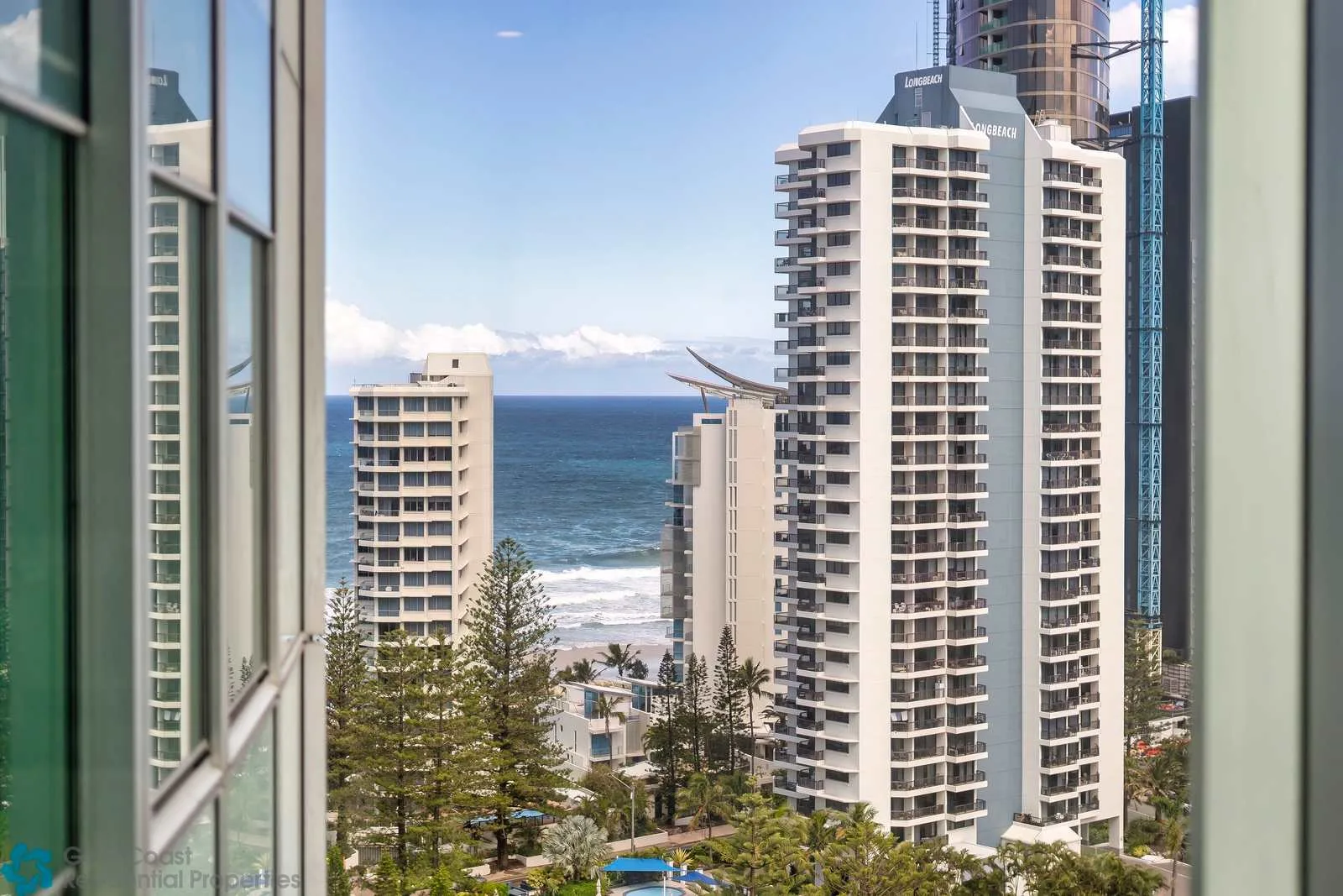 A coastal city view shows high-rise buildings beside the ocean.