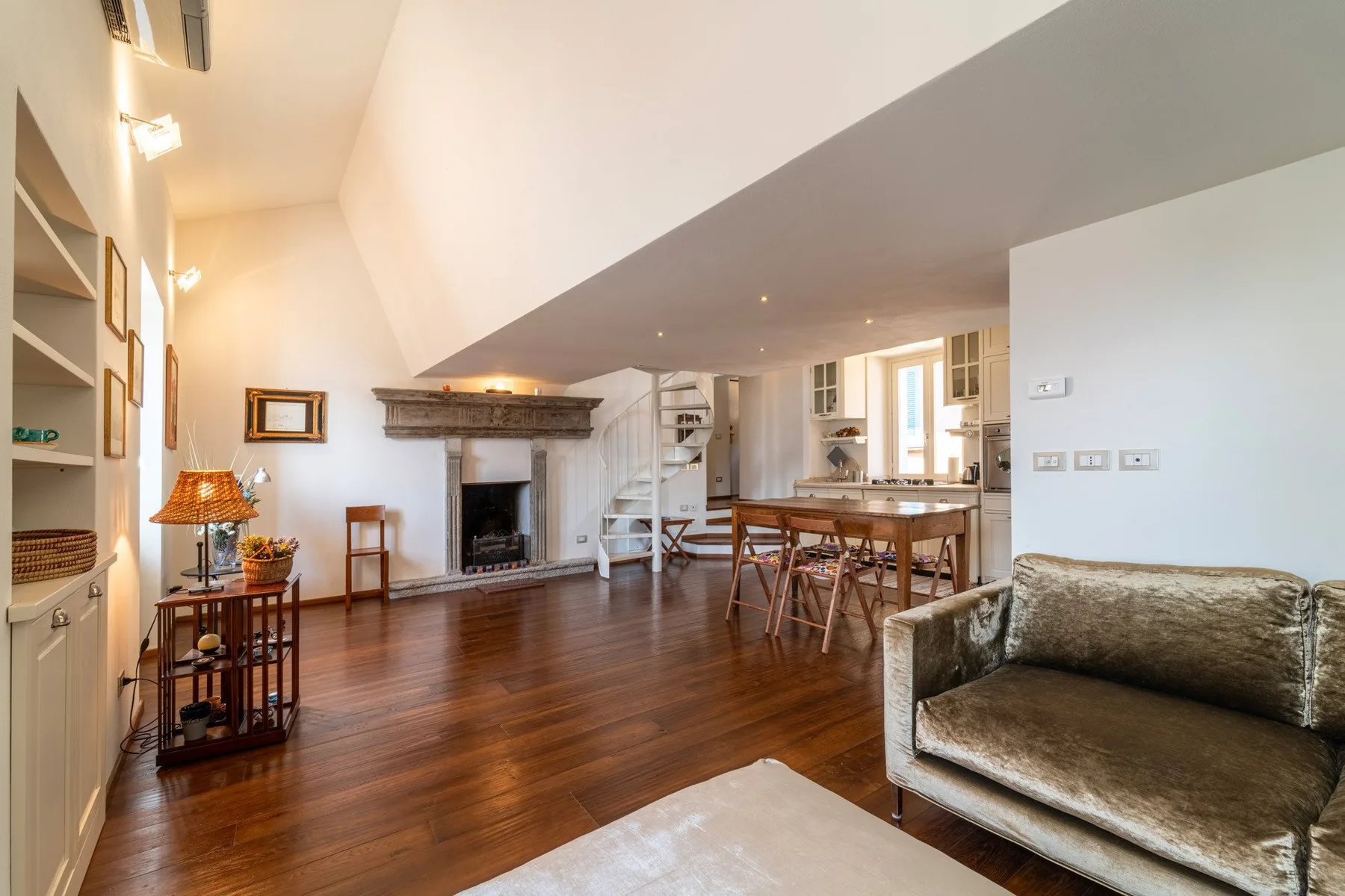 Una luminosa sala de estar y comedor cuenta con chimenea, mesa de comedor y asientos.
