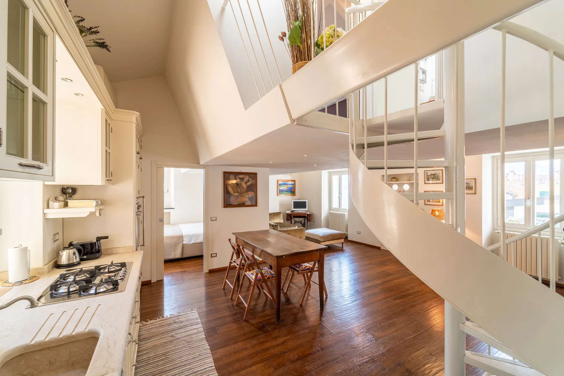 Una cocina y comedor diáfanos y luminosos quedan bajo una escalera.