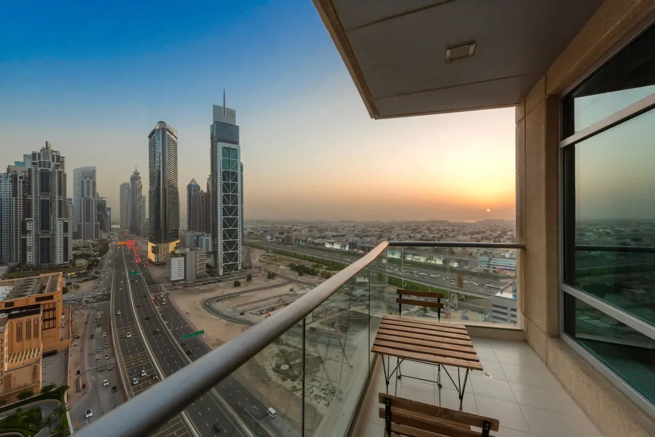 Un balcón ofrece vistas del horizonte urbano y carreteras al atardecer.