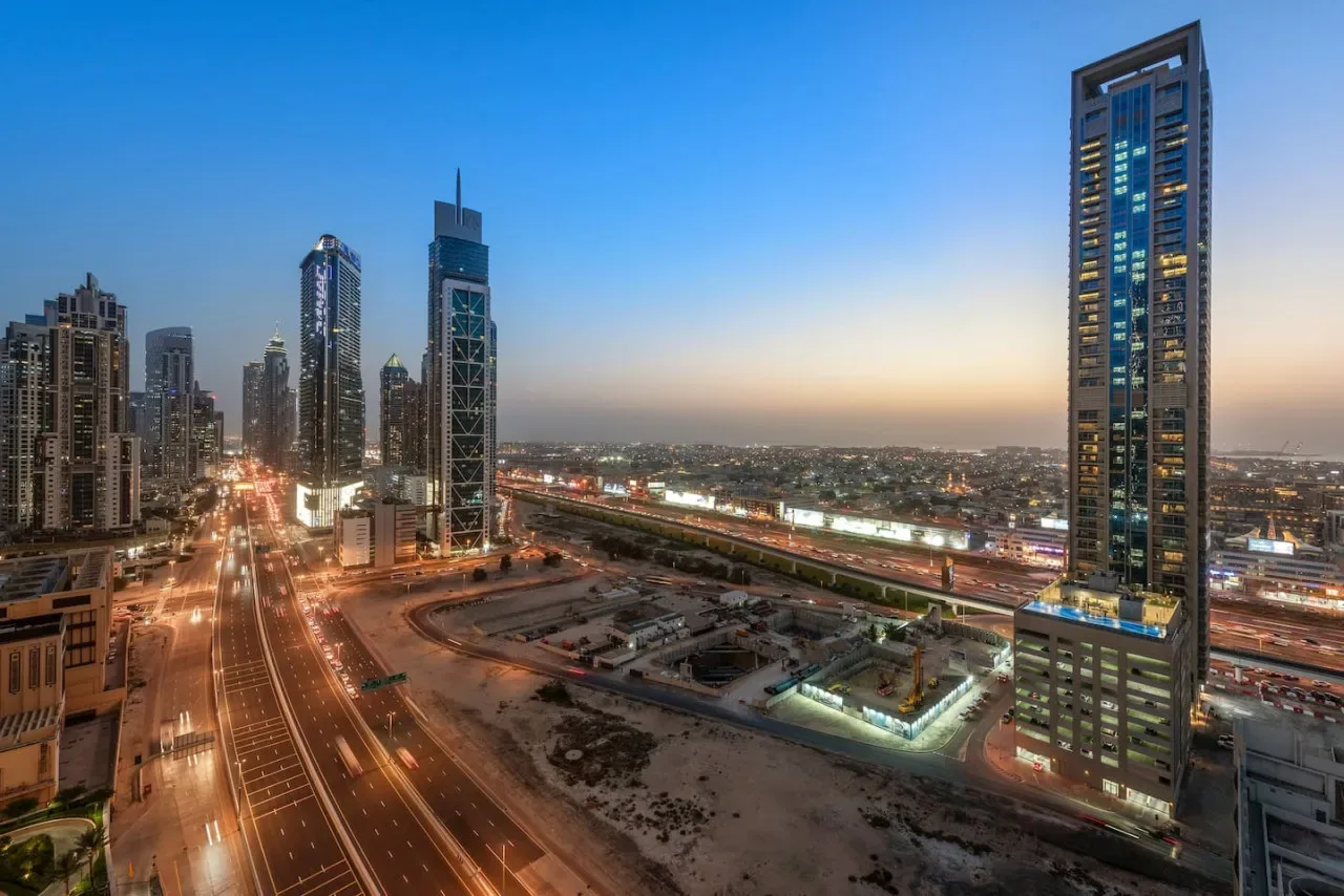 Un horizonte urbano al atardecer contempla carreteras y edificios iluminados.