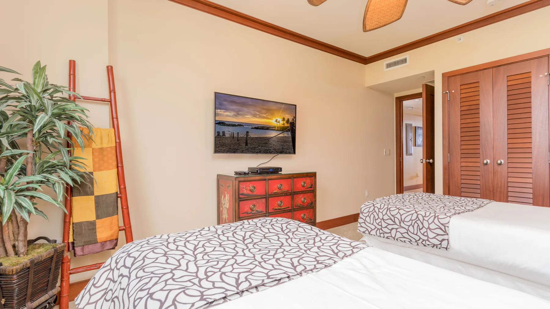 Un dormitorio con dos camas, un televisor y una cómoda.