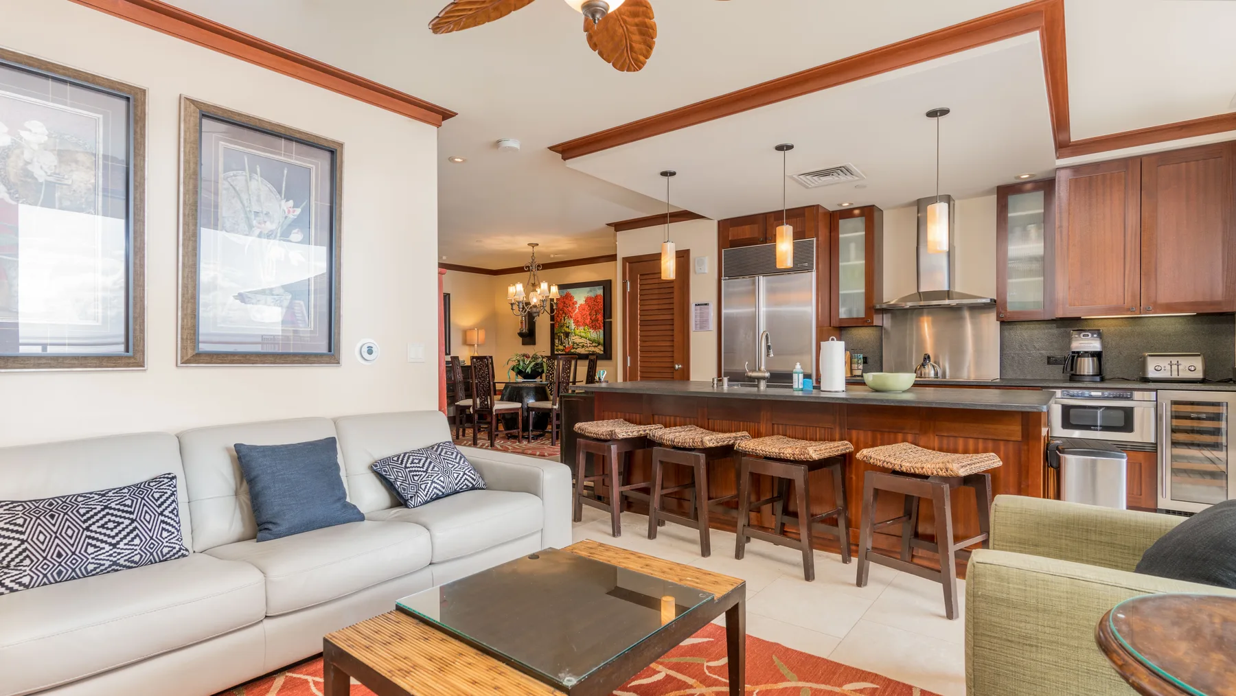 Una sala de estar y cocina de concepto abierto con una barra y asientos.