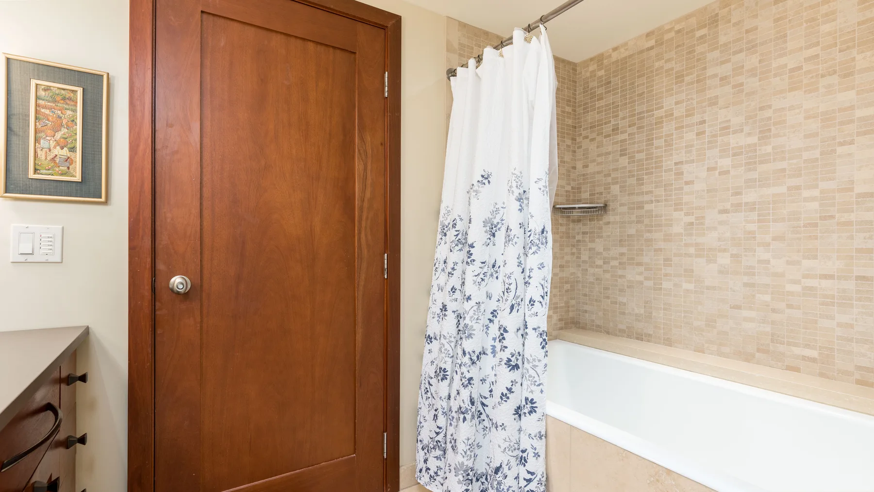 Un baño con bañera, cortina de ducha y puerta de madera.