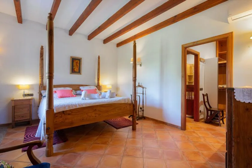 Un dormitorio con una cama de madera y vigas vistas en el techo.