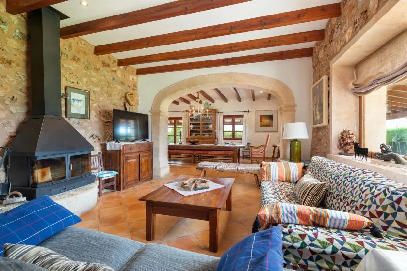 Una sala de estar rústica con vigas vistas y asientos alrededor de una mesa de centro de madera.