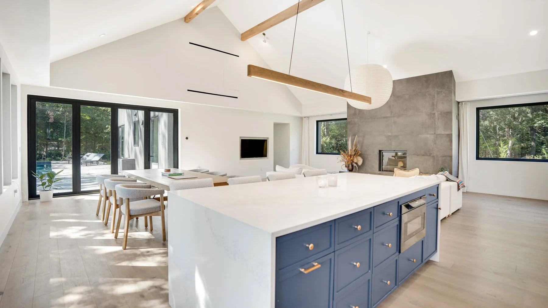 Una luminosa cocina y comedor de planta abierta con una gran isla y una mesa de comedor.