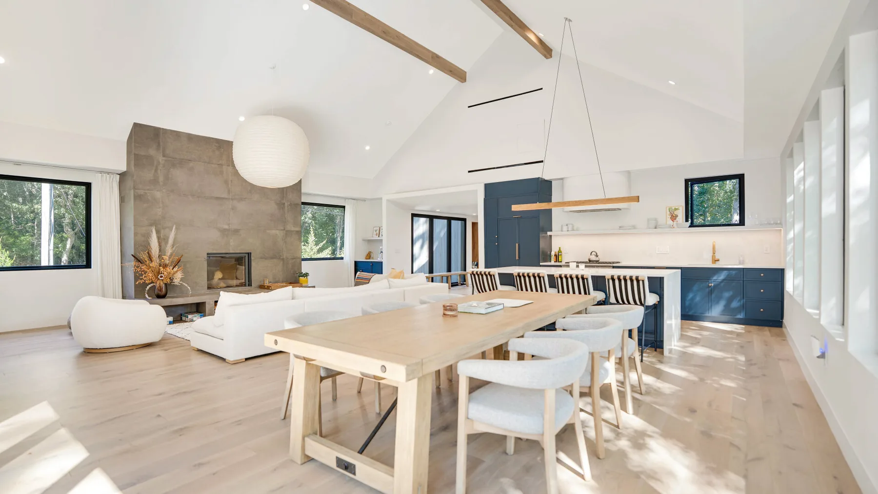 Una luminosa sala-comedor de concepto abierto con una mesa larga de madera y asientos.