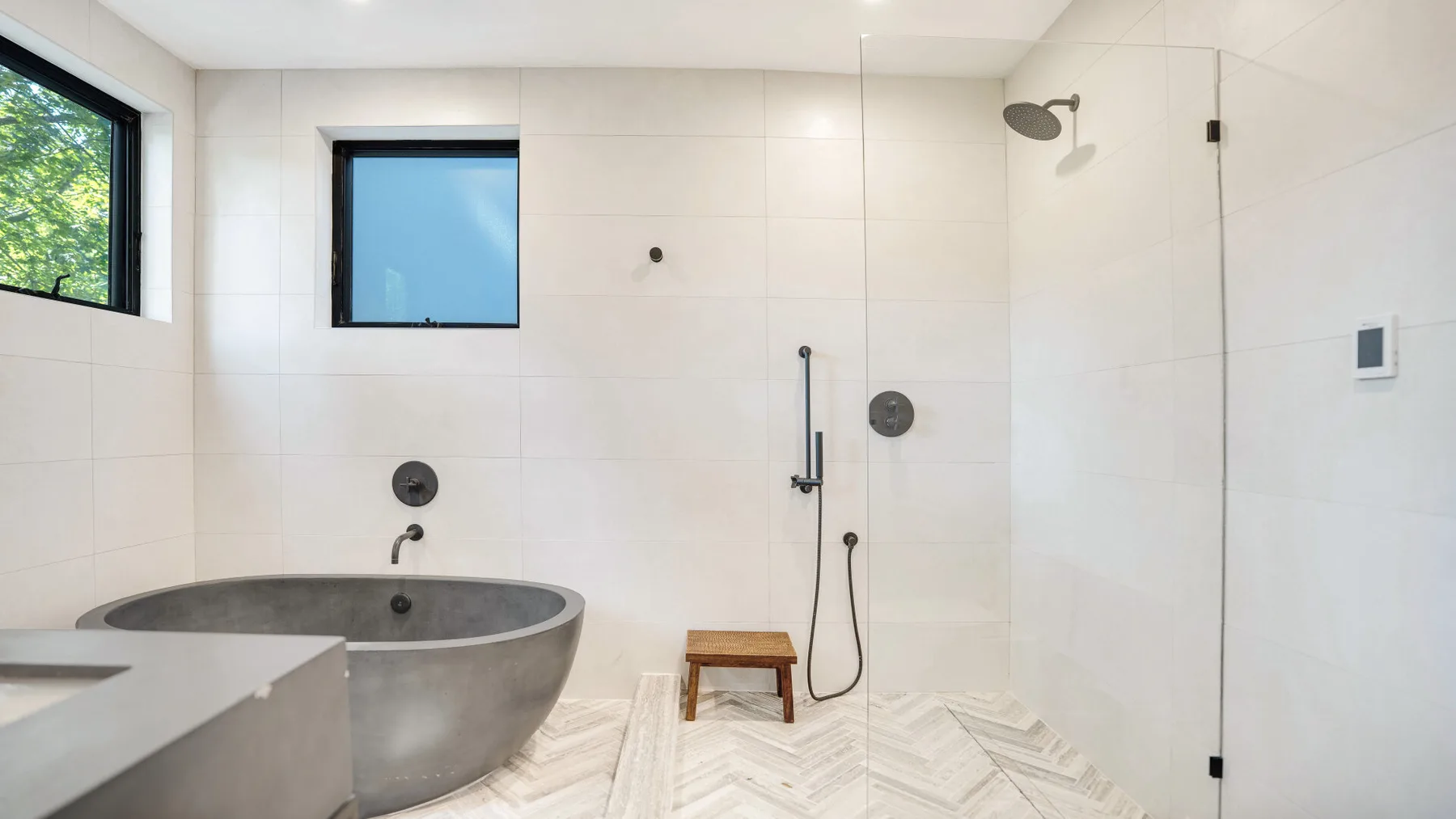 Un baño luminoso con azulejos, bañera exenta y ducha.