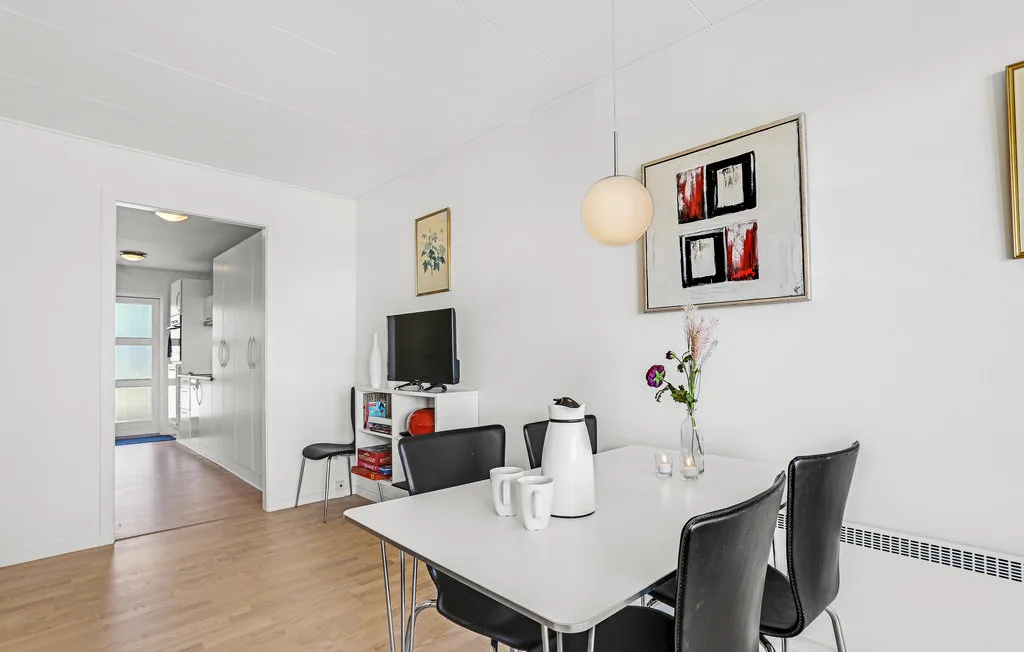 Dining area with a table and seating beside a doorway to another room.