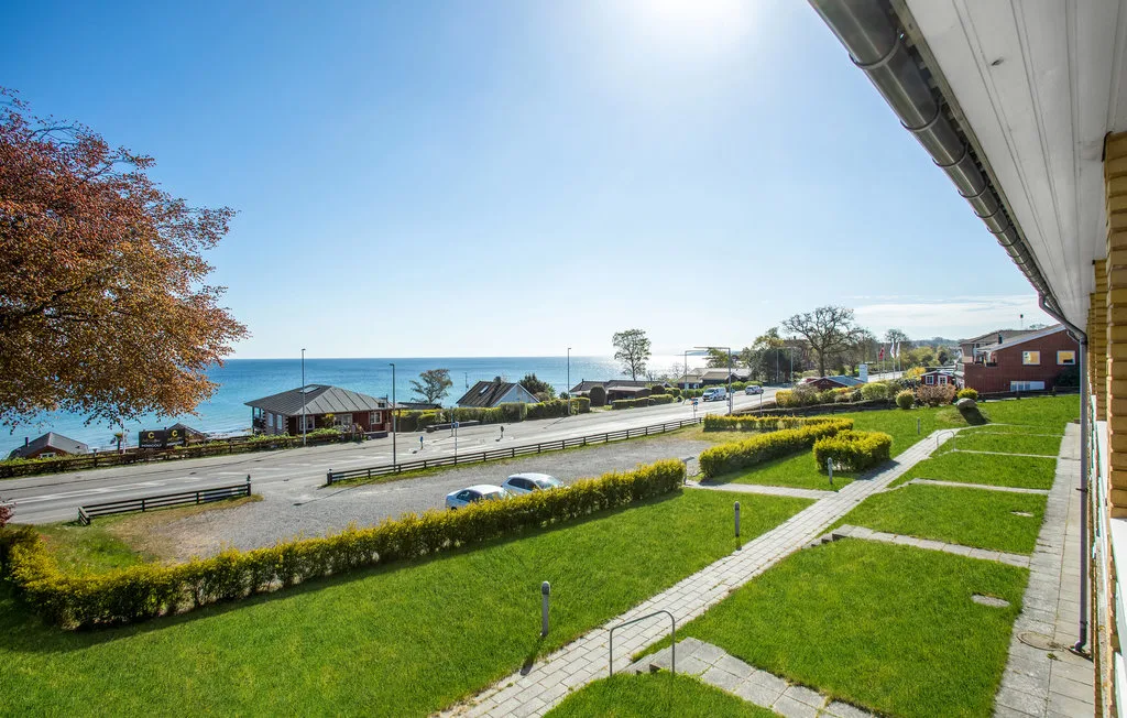 Outdoor view of a landscaped lawn and road beside the water.
