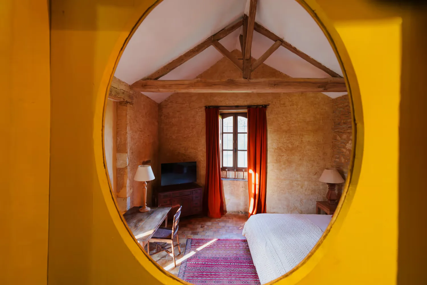 Bedroom with a bed, desk and exposed beams