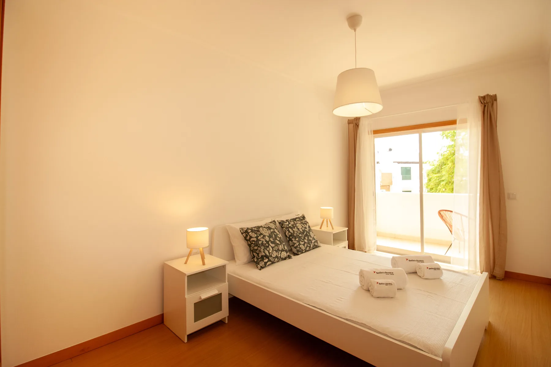 Un dormitorio con una cama y una ventana luminosa que da a un balcón.