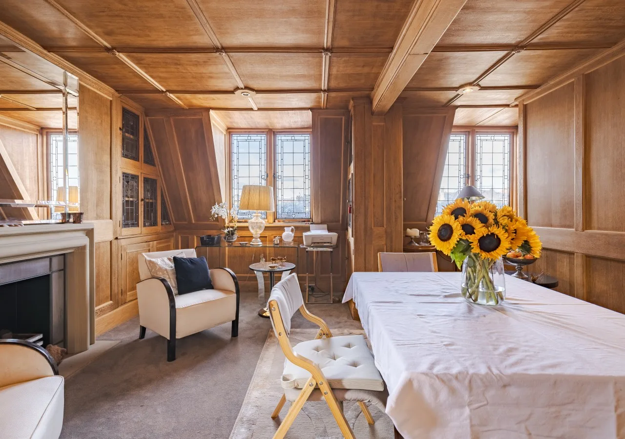 Comedor revestido de madera con una mesa larga y girasoles.