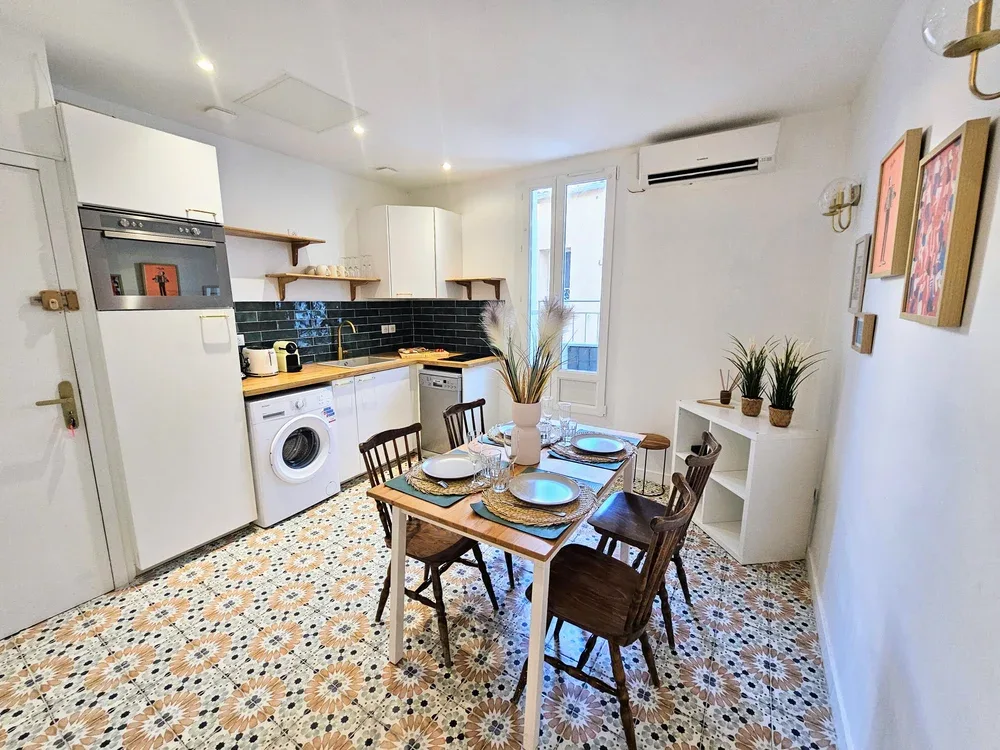 A compact kitchen and dining area with a table set beside the window.