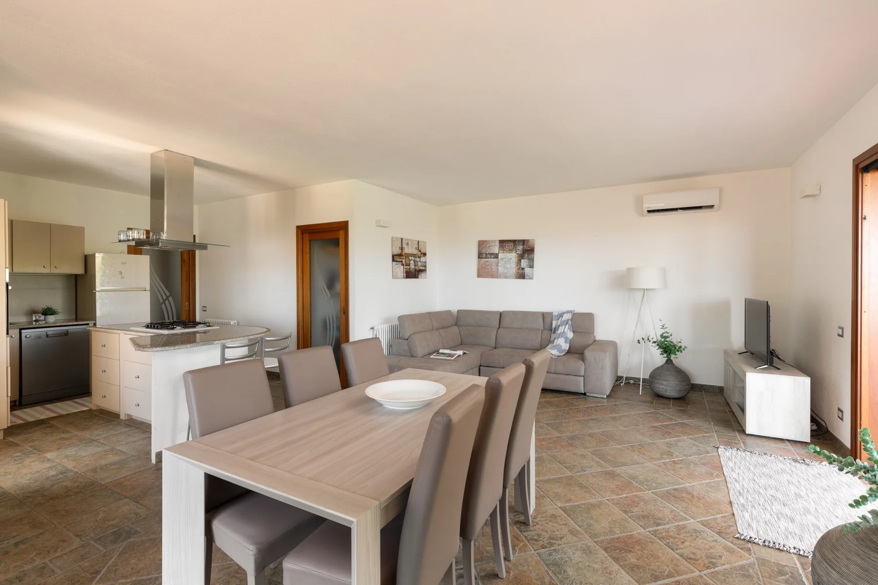 A living and dining area with a kitchen, seating, and a dining table.
