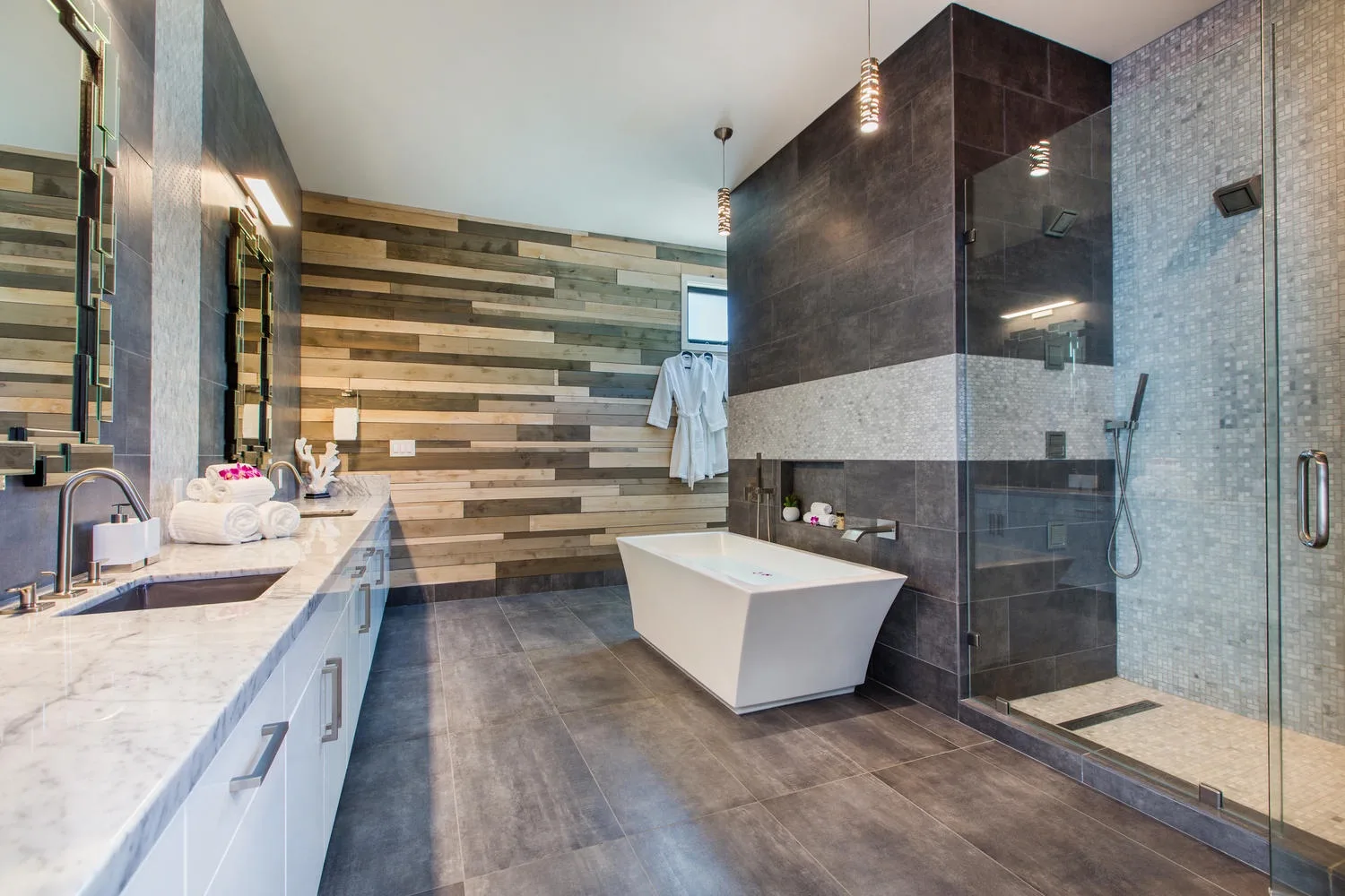 Un baño moderno con bañera exenta y ducha de cristal.