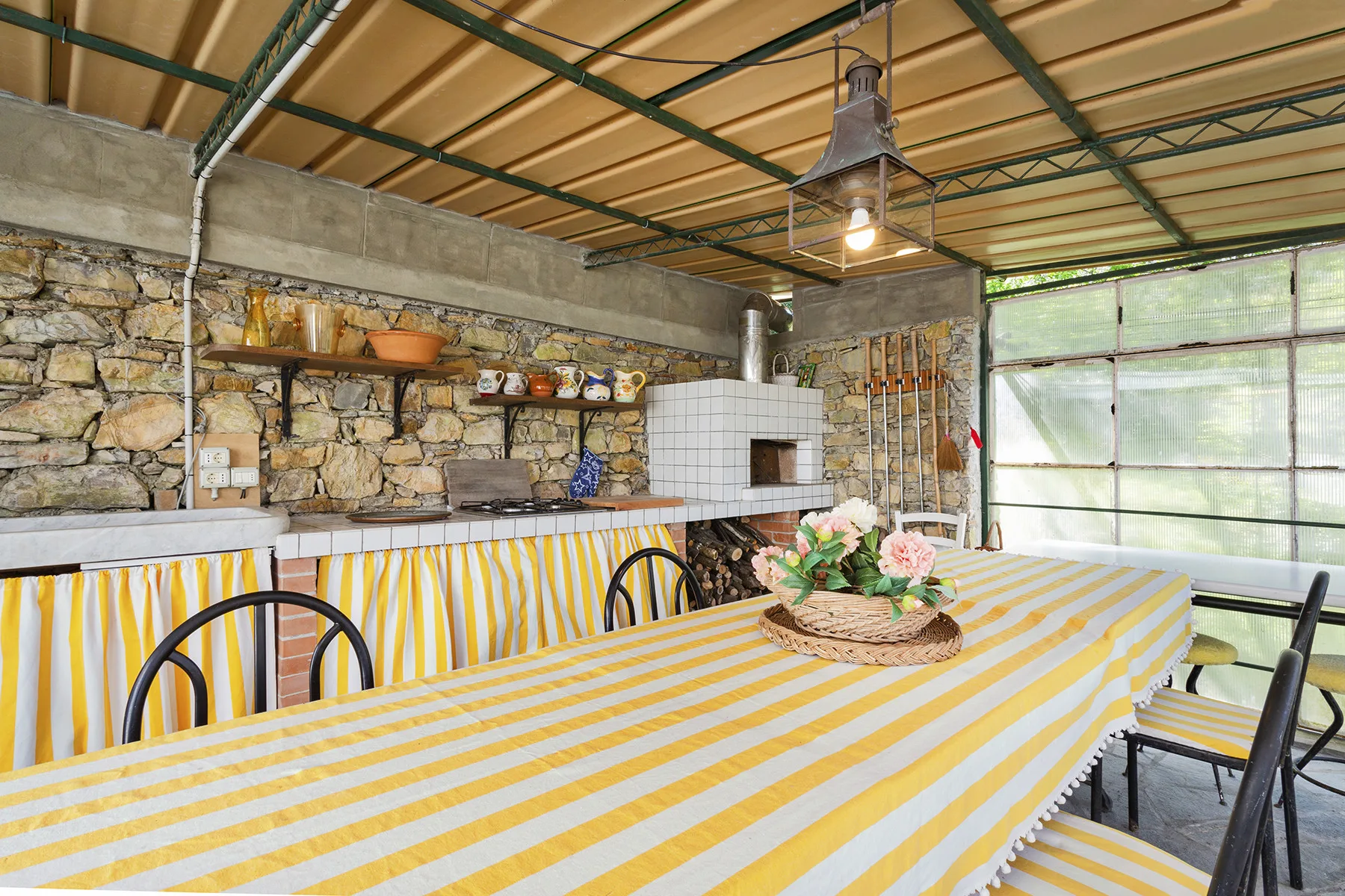 Un comedor cubierto con una mesa larga y una pared de piedra.