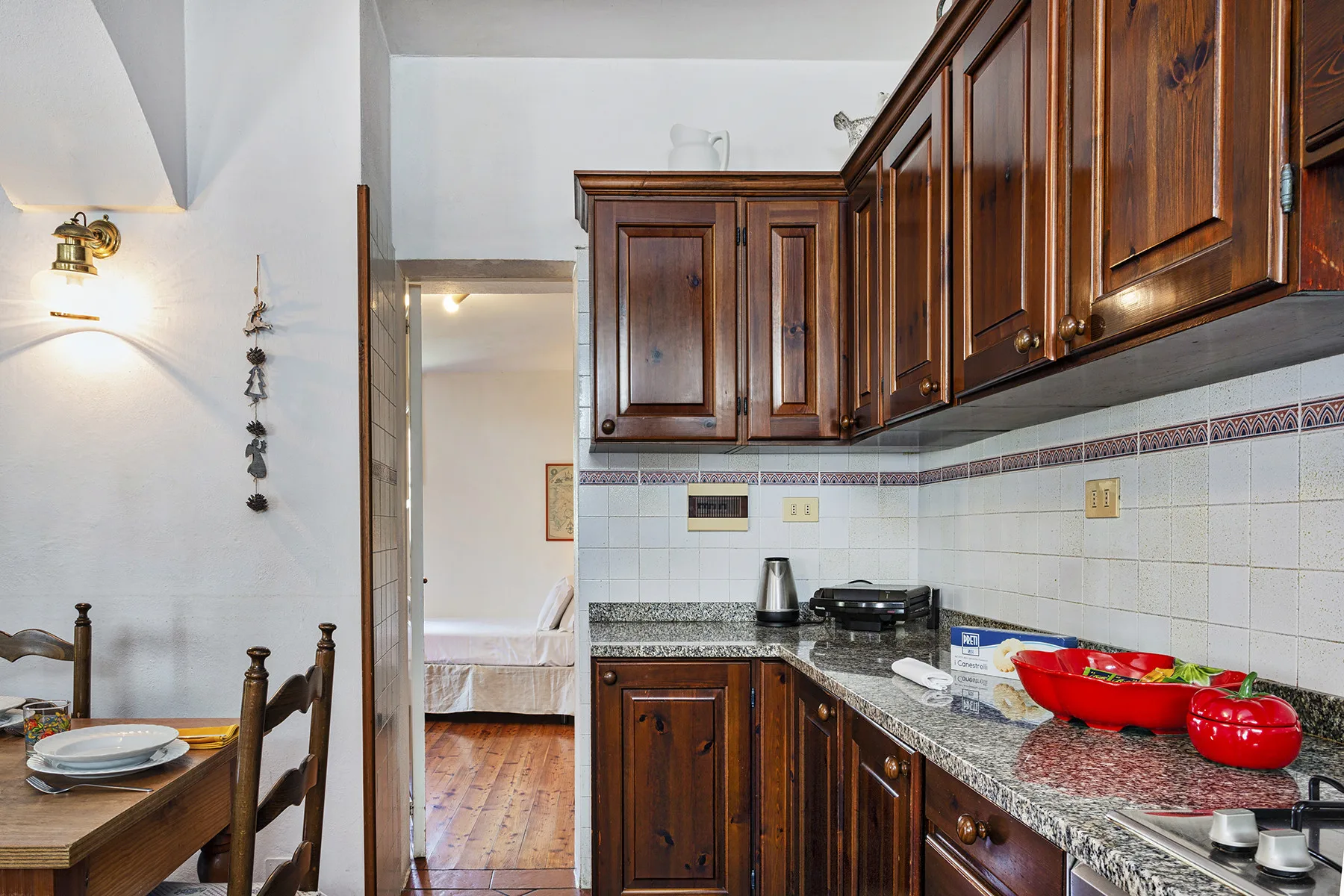 Una cocina compacta con armarios de madera oscura y un salpicadero de azulejos.