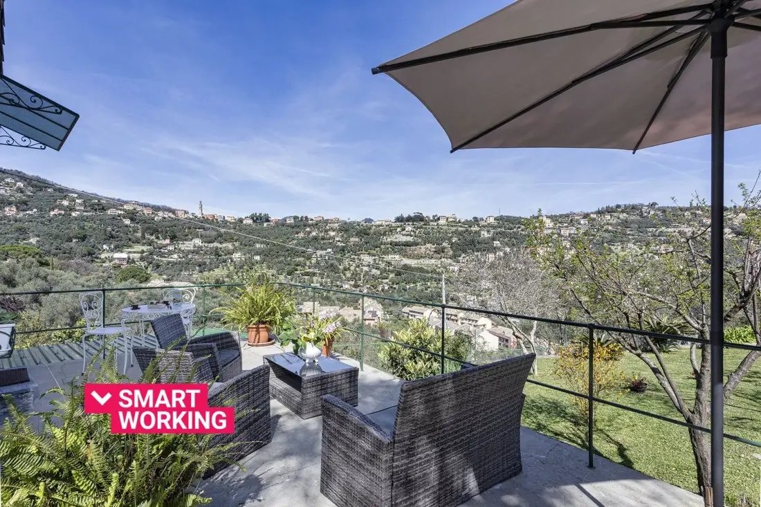 Una terraza en la ladera con asientos al aire libre mira hacia un valle verde.