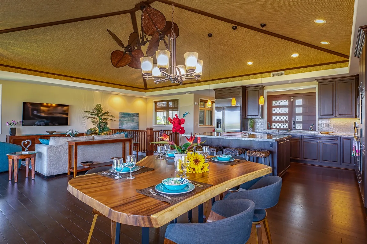 Una cocina y comedor de planta abierta con una mesa de madera y asientos de sala.