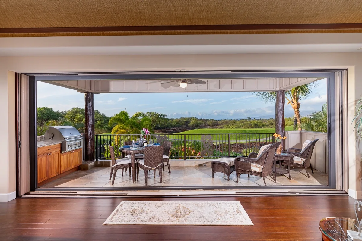 Una amplia sala se abre a un patio amueblado con vistas a la vegetación.