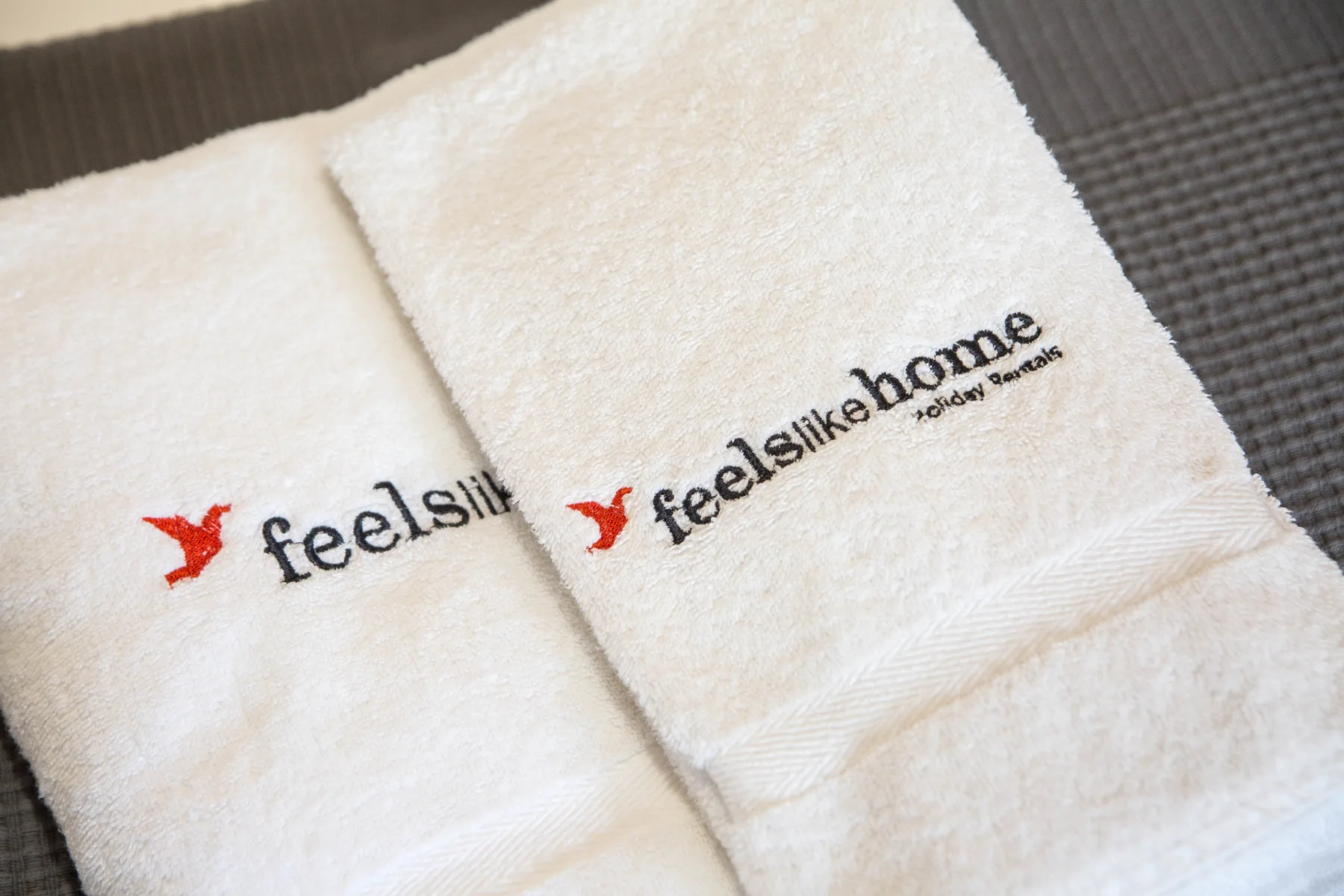 White branded towels are arranged together in a close-up.