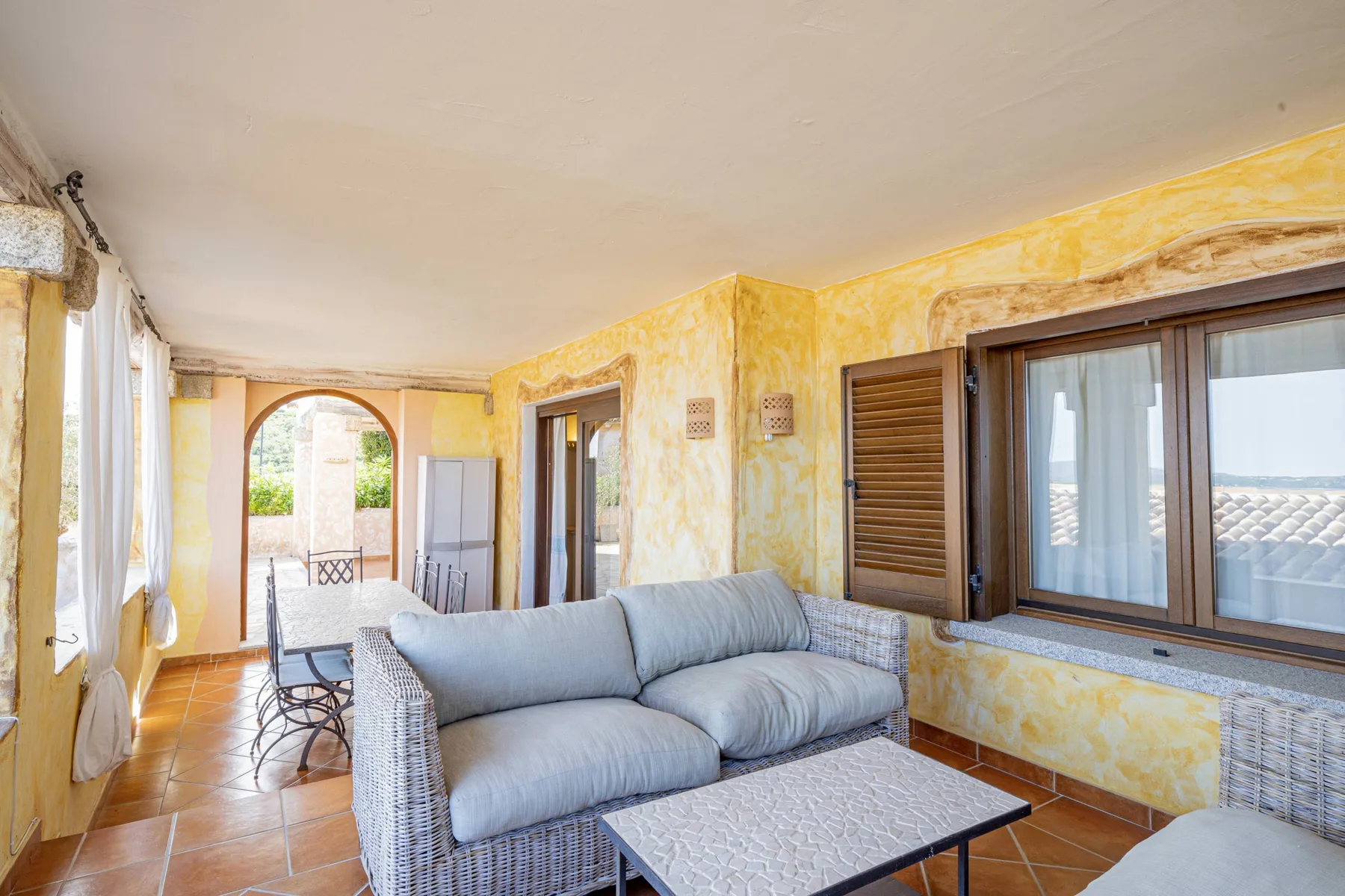 Una sala luminosa con una zona de asientos acolchados y una ventana amplia.