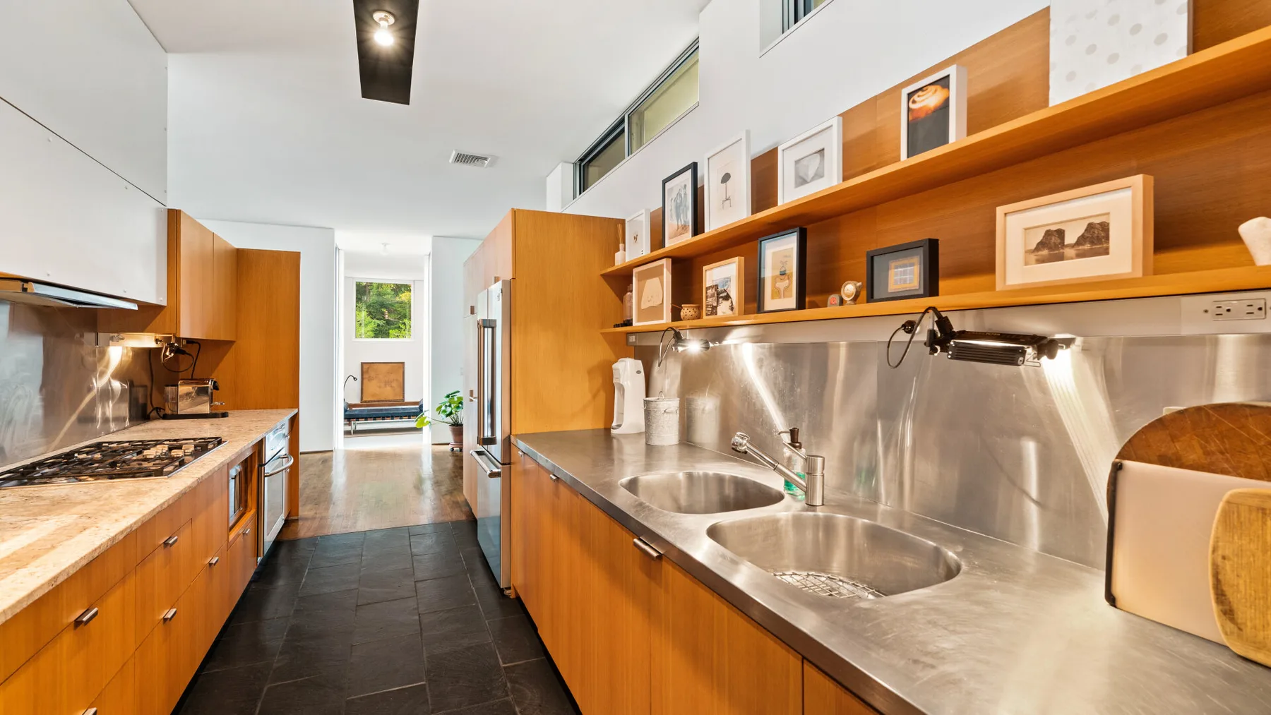 A kitchen with wooden cabinets, a long counter, and two sinks.