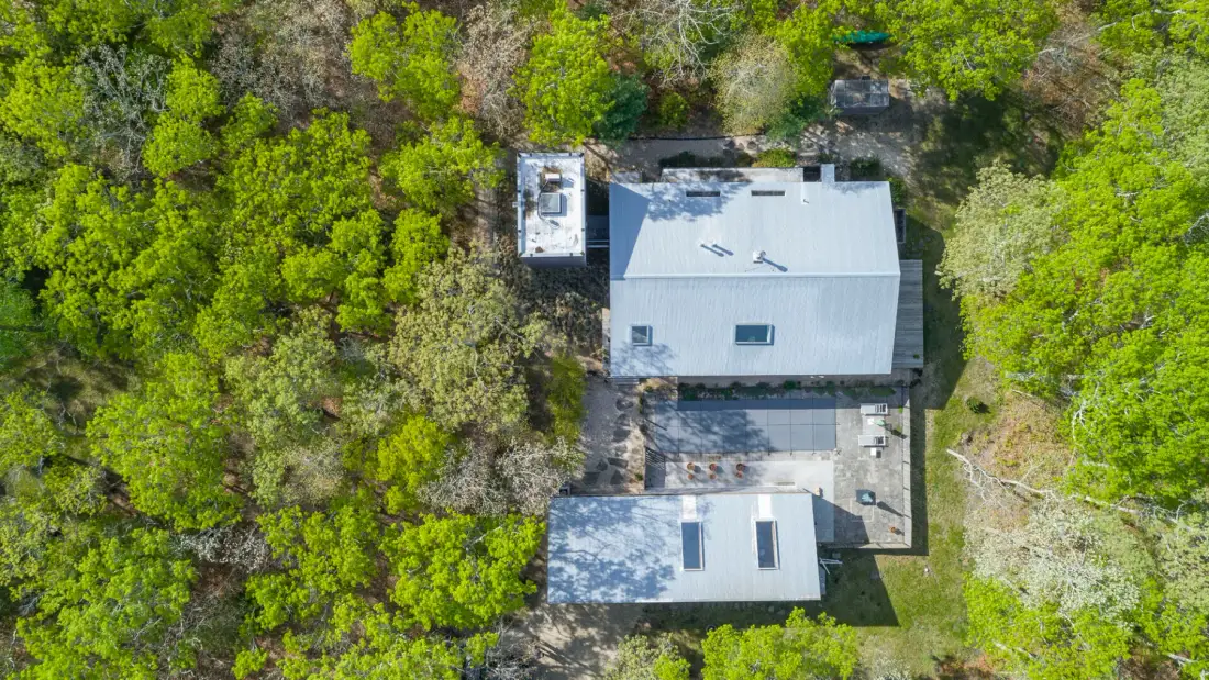An aerial view of a building surrounded by trees and greenery.