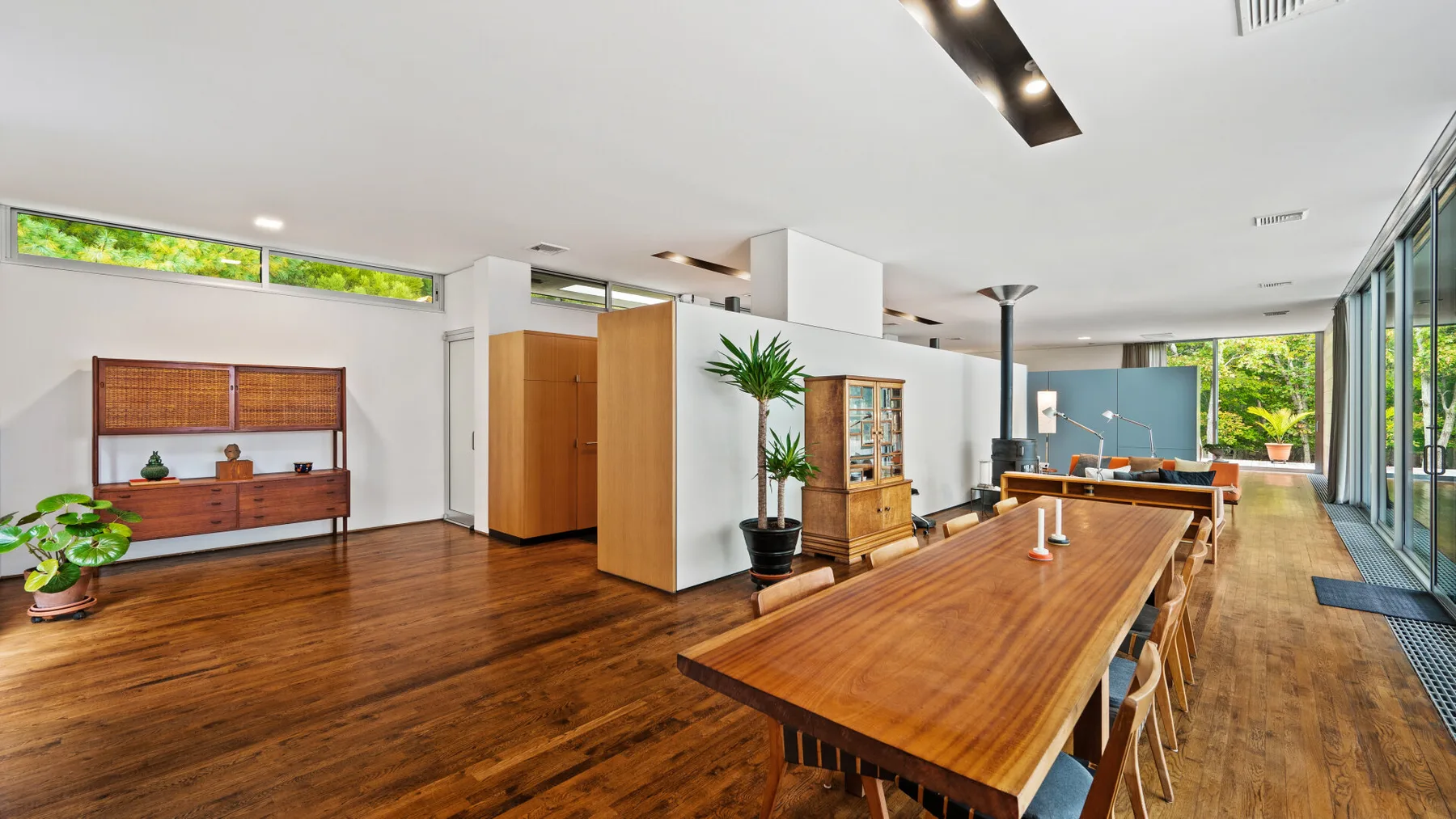 A spacious dining area with a long wooden table and large windows.