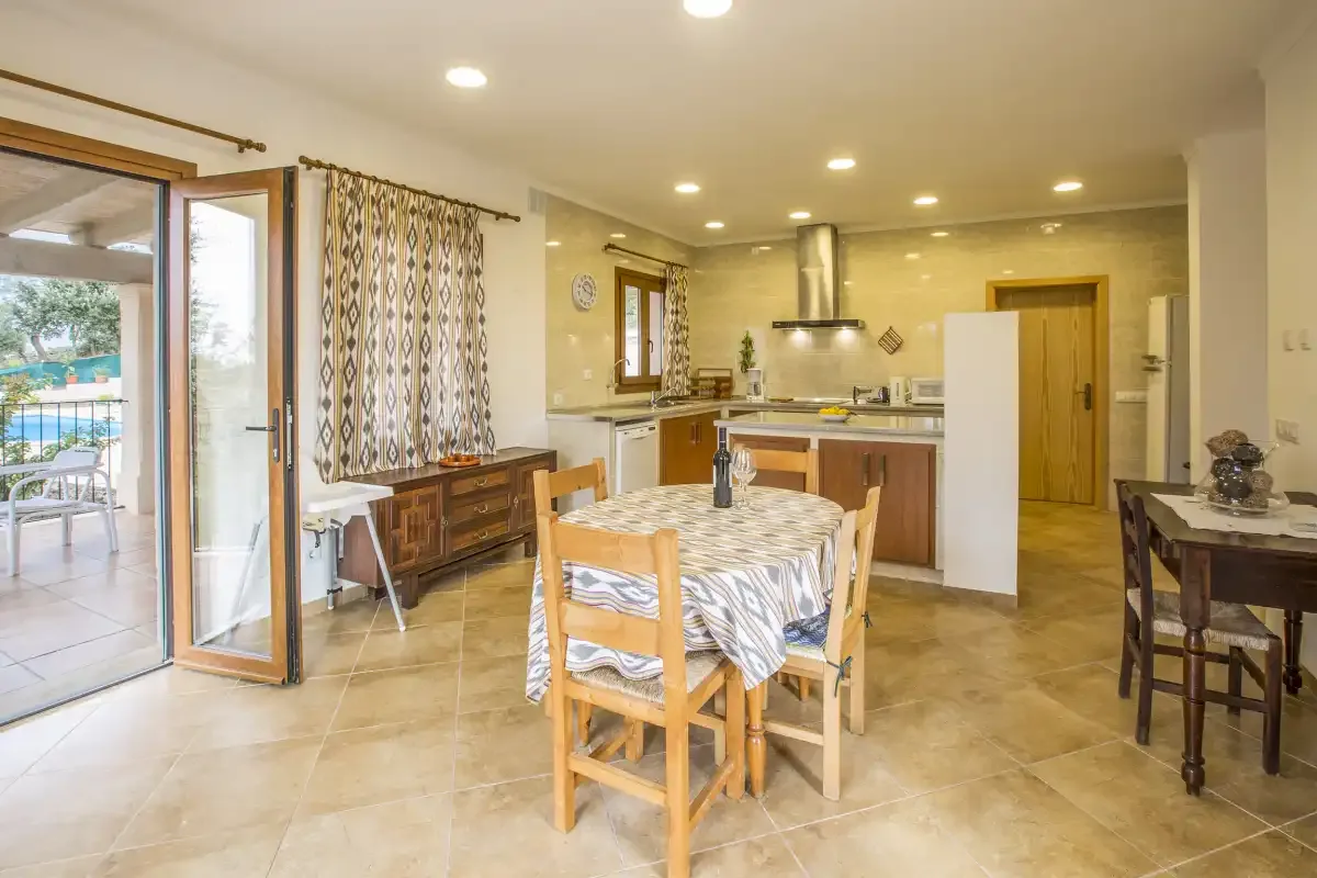 A bright kitchen and dining area with a table and sliding glass doors.