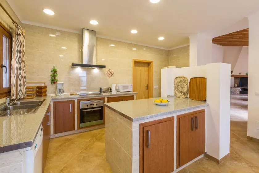 A bright kitchen with wooden cabinets and a central island.