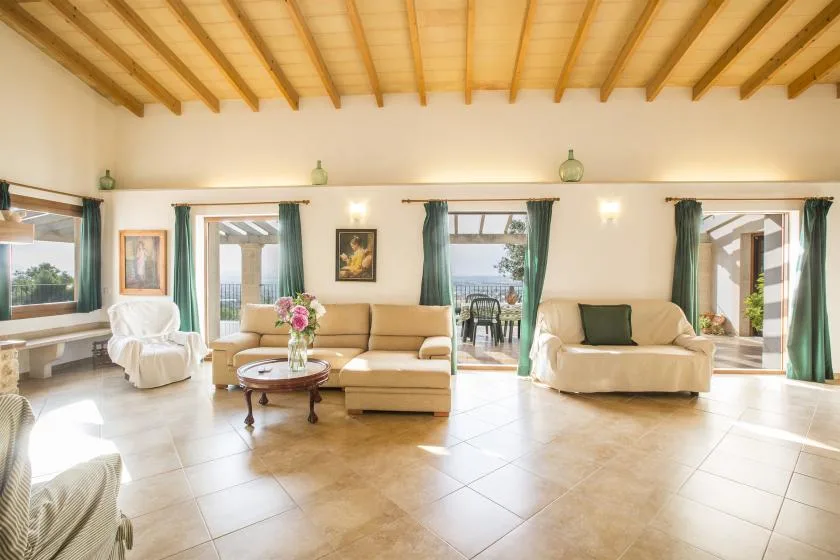 A bright living room with seating arranged around a low table and several open views.
