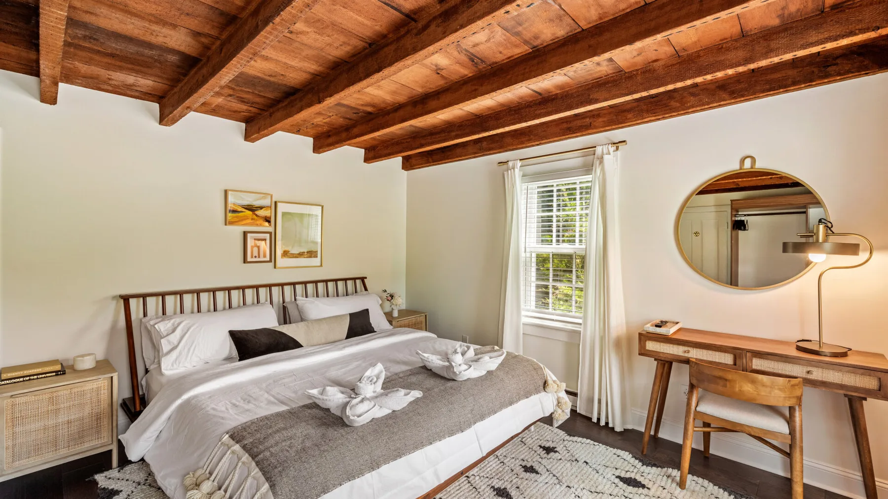 Un dormitorio con una cama grande, una ventana y un escritorio de madera.