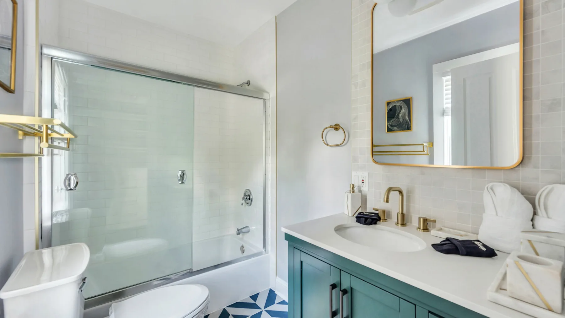 Un baño con ducha de vidrio, lavabo con mueble y espejo de pared.