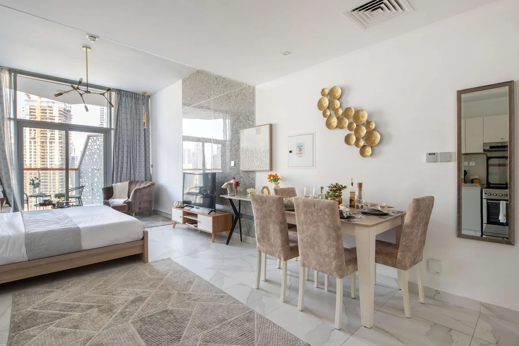 Una luminosa estancia de planta abierta combina un comedor con una cama junto a grandes ventanas.
