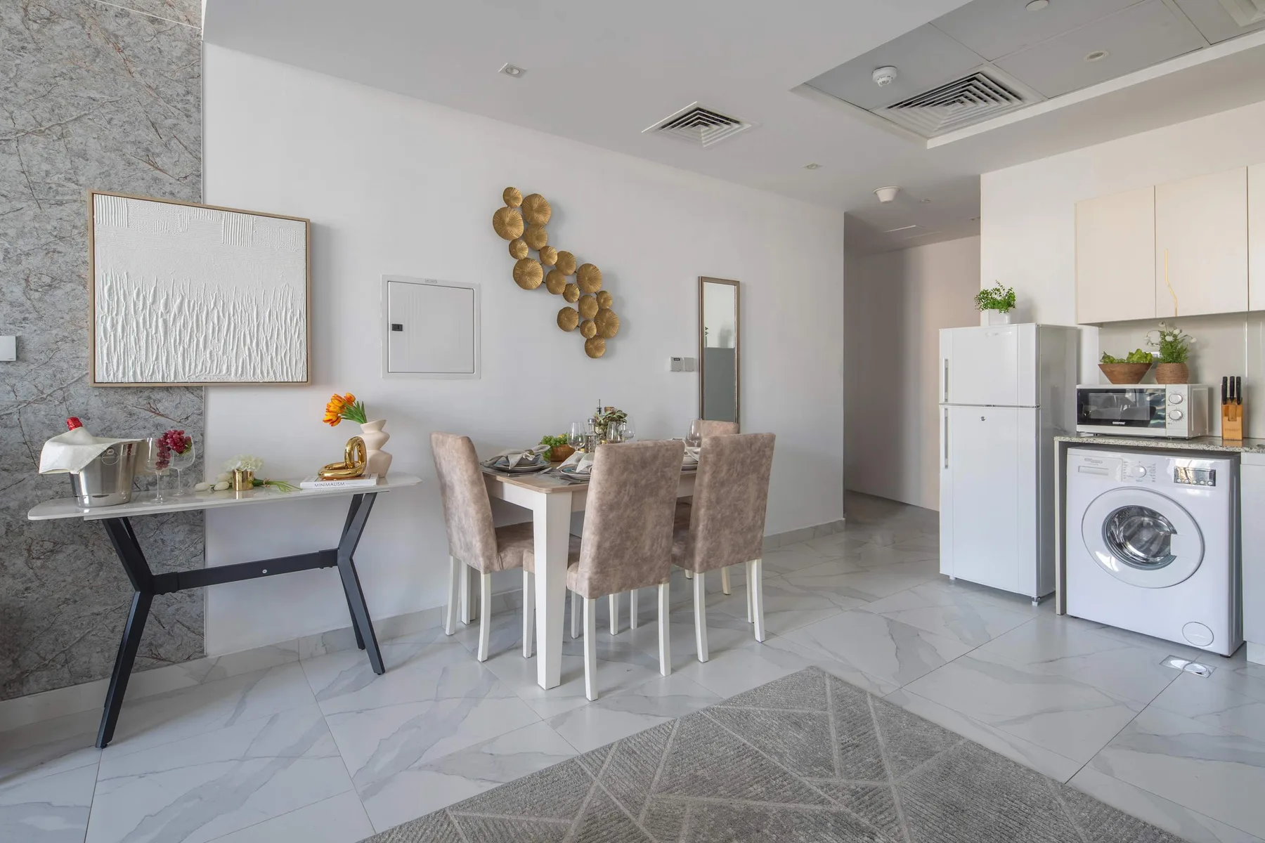 Comedor con una mesa y sillas junto a una cocina compacta.