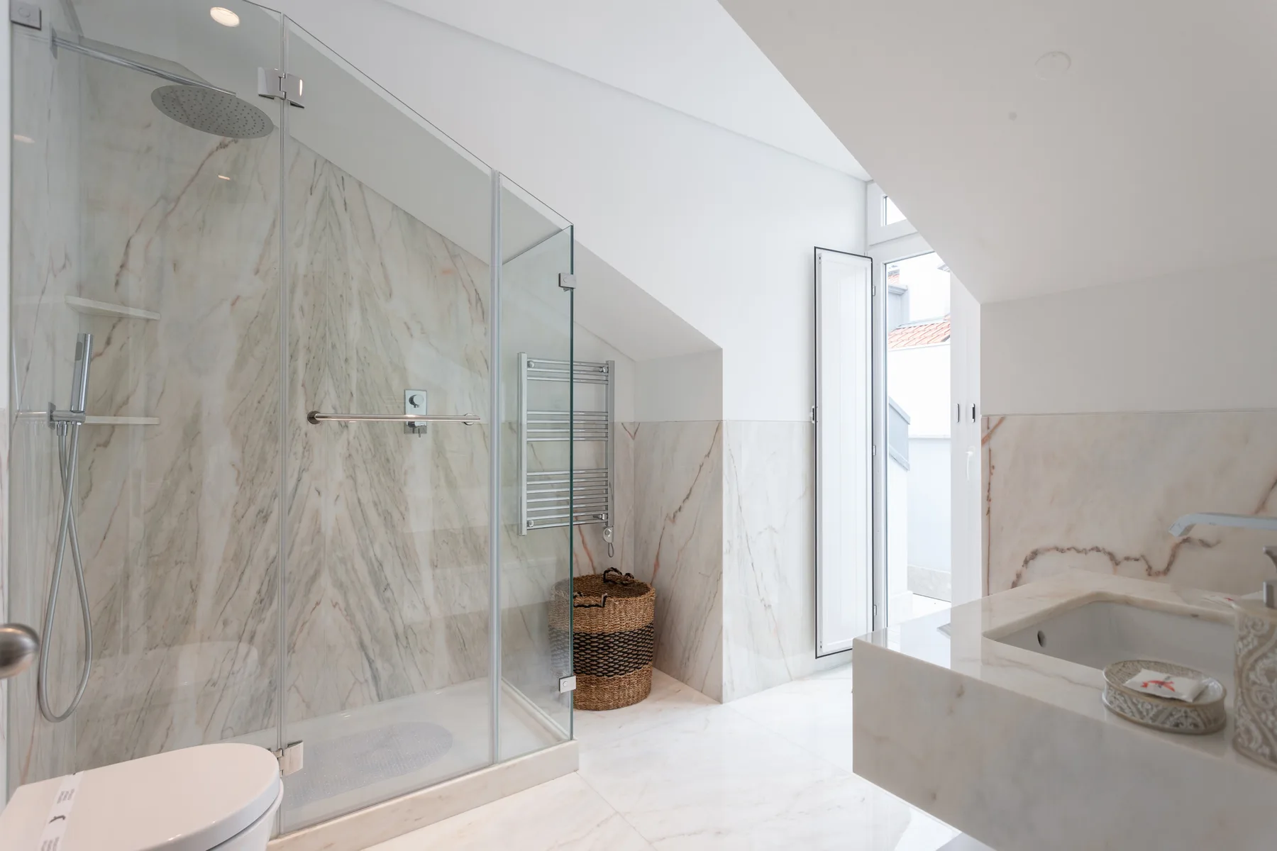A bright bathroom with a glass shower and a wide vanity.