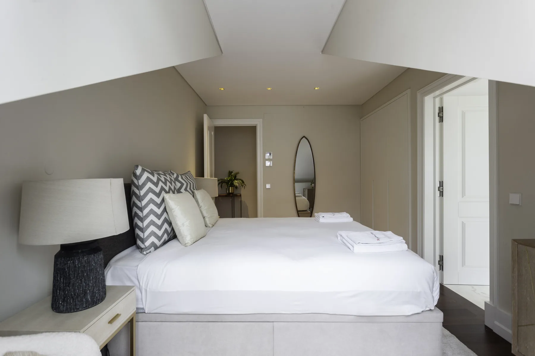 A bedroom with a neatly made bed and pillows.