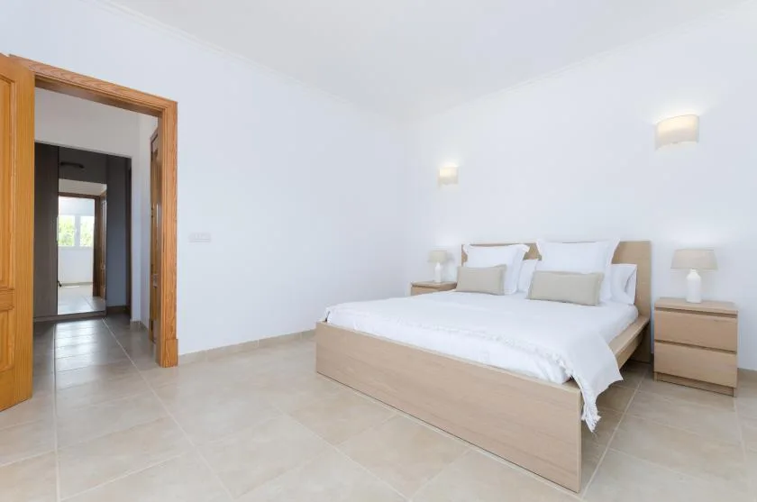 Un dormitorio luminoso con una cama y mesitas de noche a juego.
