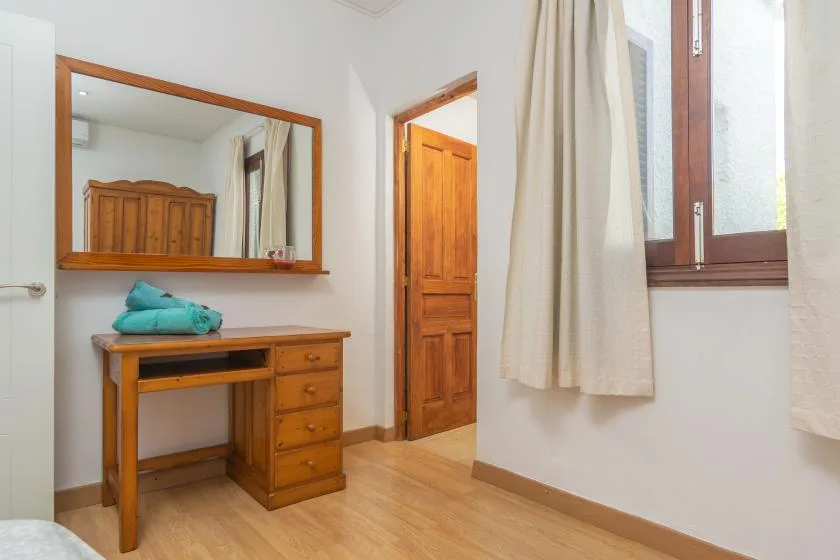 A bedroom vanity with a mirror and wooden door.
