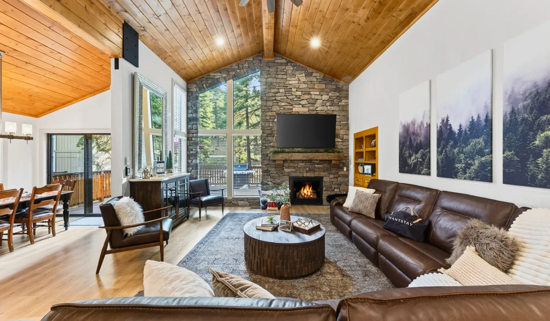 Una sala de estar con asientos alrededor de una mesa de centro y una chimenea de piedra.