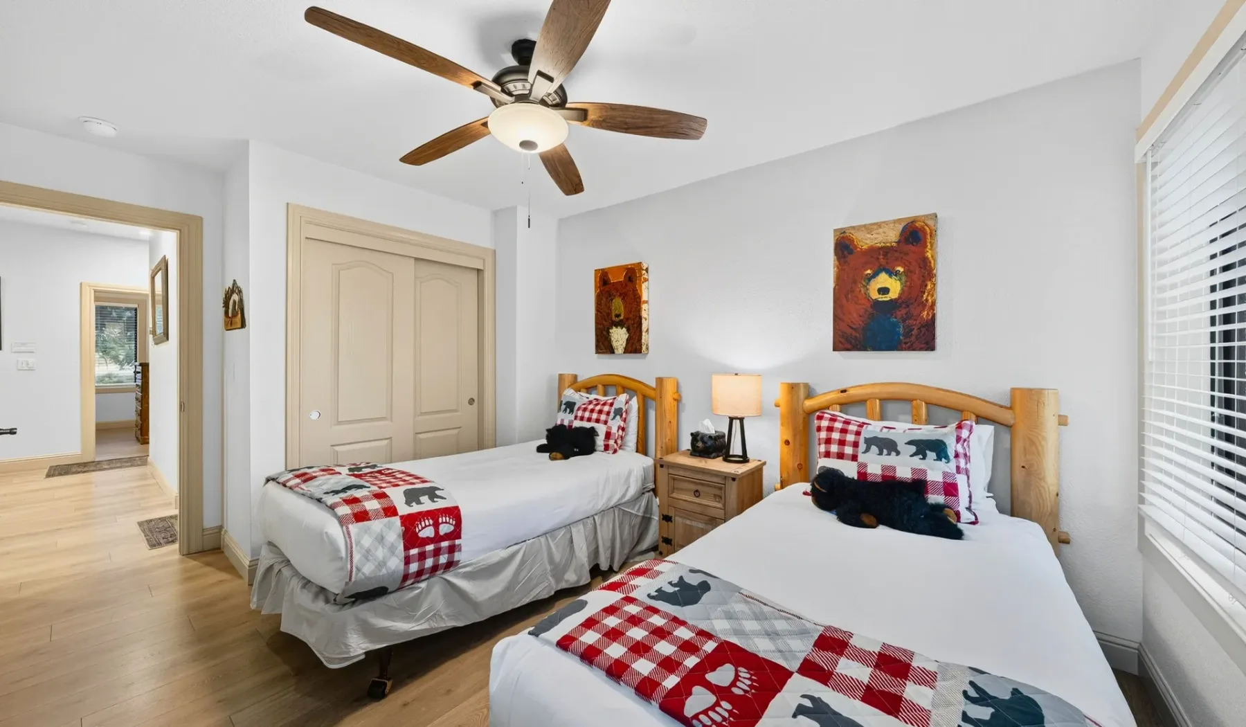 Un dormitorio con dos camas, mesitas de noche y un ventilador de techo.