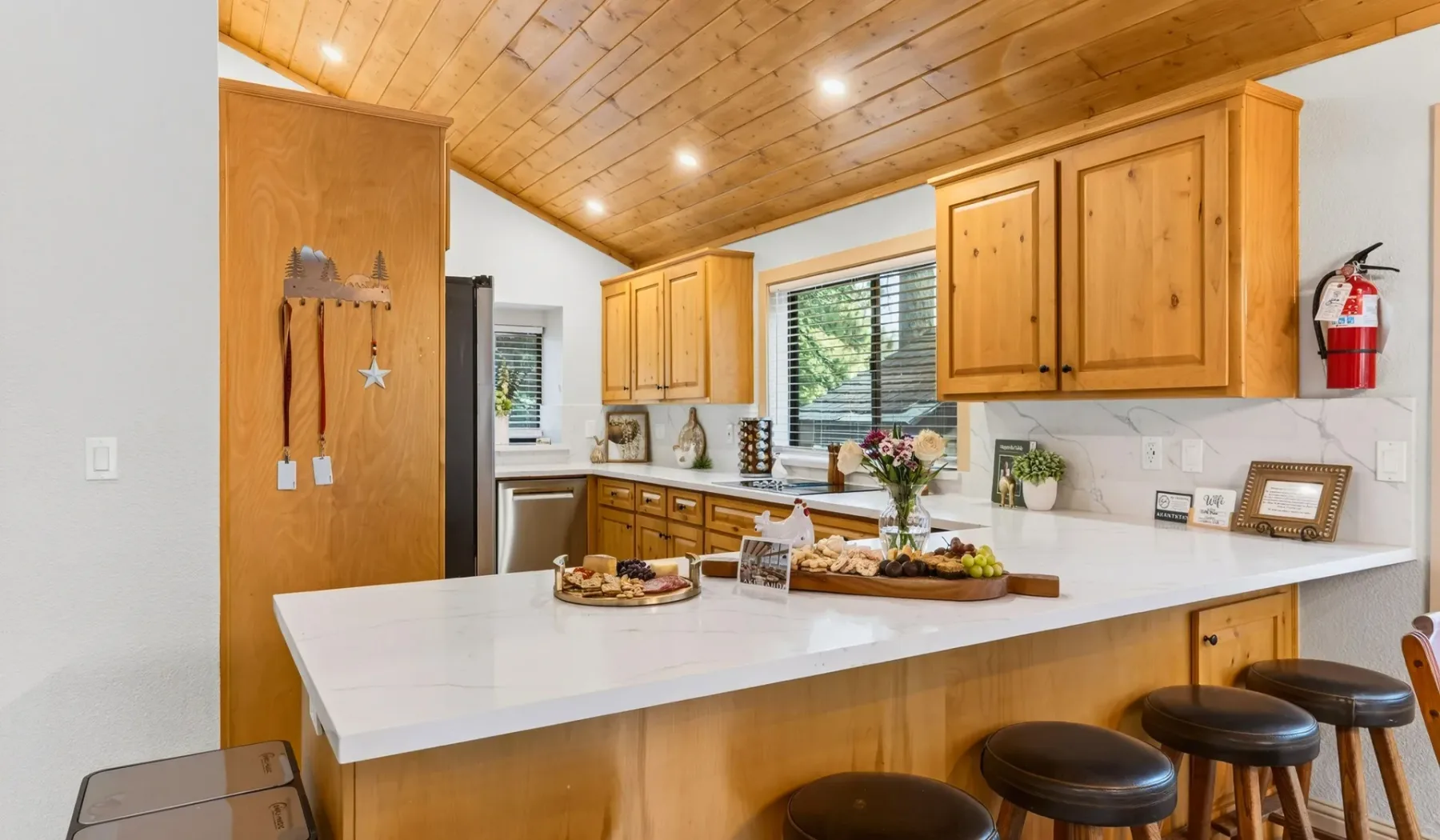 Una cocina con una amplia isla blanca y gabinetes de madera.